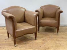 A pair of Edwardian club chairs, in tan leather upholstery embellished with studded detail, raised