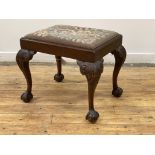 A late 19th century mahogany footstool of Chippendale design, the needlepoint upholstered drop in