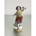 A late 19th century Meissen figure of a boy holding a floral garland, incised "F67" to the base,