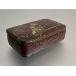 A Persian papier mache snuff box, 19th century, of oblong form, the cover decorated with a