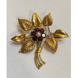 A vintage 9ct gold foilate spray brooch, set to the centre with a seed pearl within a band of