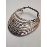 A white metal multi-ring collar, probably Tibetan, each graduated ring carved in relief with