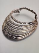 A white metal multi-ring collar, probably Tibetan, each graduated ring carved in relief with
