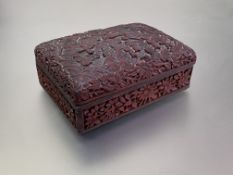 A Chinese cinnabar lacquer box and cover, of rectangular form, the slightly domed cover carved in