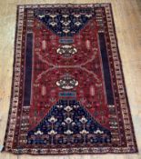 A North West Persian rug, hand knotted, the red field of stylised foliate design within multiple