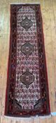 A Persian Hamadan runner rug, hand knotted, with triple medallion on ivory field framed within