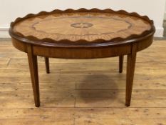 A Georgian design inlaid mahogany low table, the oval top with scalloped tray edge enclosing an