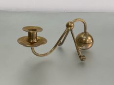 In the manner of W.A.S. Benson, an Arts & Crafts brass counterweight candlestick, the spherical