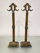 A pair of brass andirons, c. 1920, cast with scrolls and flowerheads, on rectangular bases and