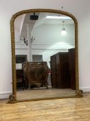 A large Victorian gilt framed arched overmantel mirror, the frame with bead and oak leaf moulding,