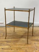 A mid 20th century brass faux bamboo two tier etagere, each tier inset with gilt tooled leather,