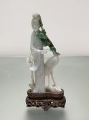 A Chinese jadeite carving of a female Immortal standing beside a crane, a flowering bough in her