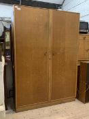 Meredew, A mid century light oak veneered wardrobe, with two doors enclosing a mirror, shelf and