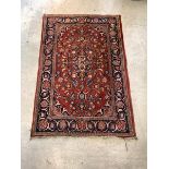 An old Persian Tabriz design rug, hand knotted, the red field having blue medallion and interlaced