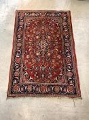 An old Persian Tabriz design rug, hand knotted, the red field having blue medallion and interlaced