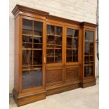 An Edwardian mahogany inverted break front bookcase, the moulded top over centre fitted with two