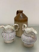 A pair of 19thc china fluted jugs decorated with C scroll handles and multicoloured panelled