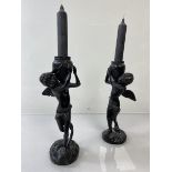 A pair of cast metal winged young boys carrying jars (each: 22cm to top of jar)