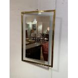 A brass rectangular framed wall mirror with glazed panel with mirrored section (92cm x 61cm)