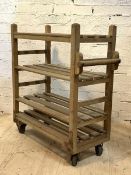 A mid 20th century bakers trolley, with four slatted tiers raised on castors, H115cm, W104cm, D46cm