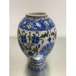 An Iznik style baluster vase, the centre panel with stylised poppy and lotus flowers and leaves,