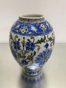 An Iznik style baluster vase, the centre panel with stylised poppy and lotus flowers and leaves,