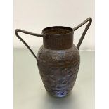 An Eastern copper hammered twin cast iron handled vase with centre panel with Arabic script enclosed