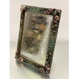 A barbola style rectangular dressing mirror with floral encrusted and fruit border, with bevelled