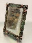 A barbola style rectangular dressing mirror with floral encrusted and fruit border, with bevelled
