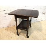 A 1920's / 30's oak hostess trolley with drop leaves to sides, single frieze drawer on turned