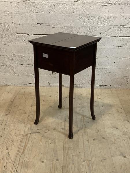 An Edwardian mahogany sewing table, with hinged top revealing storage well, raised on square splayed