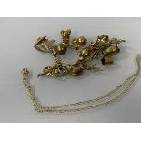 A gilt metal charm bracelet with collection of charms, most marked 9k, combined weight 47 grammes,