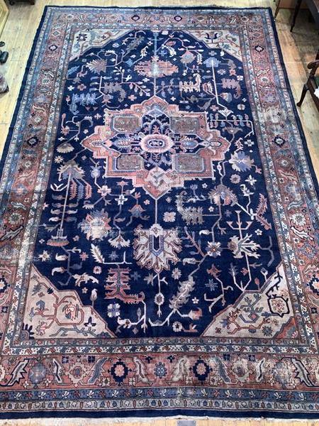 A Large Persian hand knotted carpet, the blue field decorated with geometric foliate framed within a