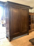 An early 20th century mahogany wardrobe, with dentil cornice, two doors with fluted detail enclosing