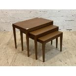 A mid century teak nest of three tables, raised on square tapered supports, H49cm, W60cm, D40cm