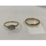 A wedding band marked 375, size U/V, weighs 2.44 grammes, and a cross over ring marked 9ct Plat,