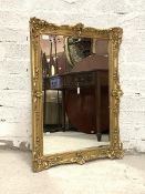 A gilt composition framed wall hanging mirror in the Rococo taste, the frame with shells and 'c'