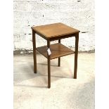 A Vintage mid century teak two tier table, the moulded top raised on square supports united by an