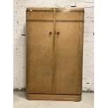 An Art Deco period birds eye maple wardrobe, the caddy top over two doors enclosing an interior