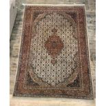 A Persian Tabriz design carpet, ivory field with medallion and multiple flower heads and