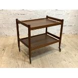 A mid century teak two tier drinks trolley, with turned supports and castors, H67cm, W72cm, D48cm