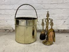 An early 20th century brass cylindrical log bucket with handle, together with brass four piece