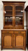 A late Victorian mahogany bookcase on cupboard, the top with three adjustable shelves over three