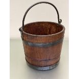 An oak iron bound coal bucket with cast iron swing handle to top (29cm x 33cm)