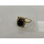 A 14k gold cluster ring with fourteen chip diamonds surrounding dark blue stone, size O/P, weighs