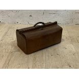 An early 20th century leather travelling case with old paper label, inscribed G to one end H34cm,