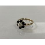 A 9ct gold cluster ring with six sapphires surrounding chip diamond, size R, weighs 3.28 grammes