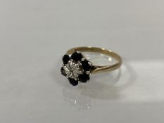 A 9ct gold cluster ring with six sapphires surrounding chip diamond, size R, weighs 3.28 grammes