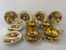 A matched Aynsley Orchard Gold teaset including tea cups with scalloped edges and another larger (