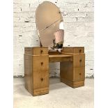 An Art Deco period bird eye maple twin pedestal dressing chest, the large bevelled swing mirror of